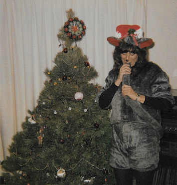Sandy in a homemade mouse costume in front of a Christmas tree